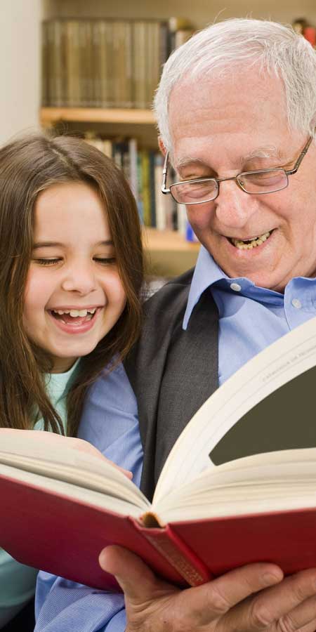 grandfather reading to granddaughter